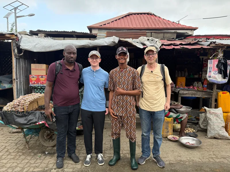 Dr. Okwong John Walter and Moses, community leader at one of the site visit locations, together with the AirGradient team